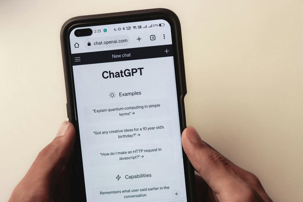 Never Run Out of Ideas: Top Tips for Generating Fresh Blog Topics Close-up of hands holding a smartphone displaying the ChatGPT application interface on the screen.